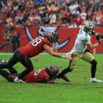 Dec 7, 2025; Tampa, Florida, USA; New Orleans Saints quarterback Tyler Shough (6) runs for a gain past Tampa Bay Buccaneers linebacker Anthony Nelson (98) and defensive tackle Vita Vea (50) during the fourth quarter at Raymond James Stadium. Mandatory Credit: Kim Klement Neitzel-Imagn Images