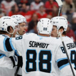 Dec 17, 2025; Detroit, Michigan, USA; Utah Mammoth right wing Dylan Guenther (11) receives congratulations from teammates after scoring in the third period against the Detroit Red Wings at Little Caesars Arena. Mandatory Credit: Rick Osentoski-Imagn Images