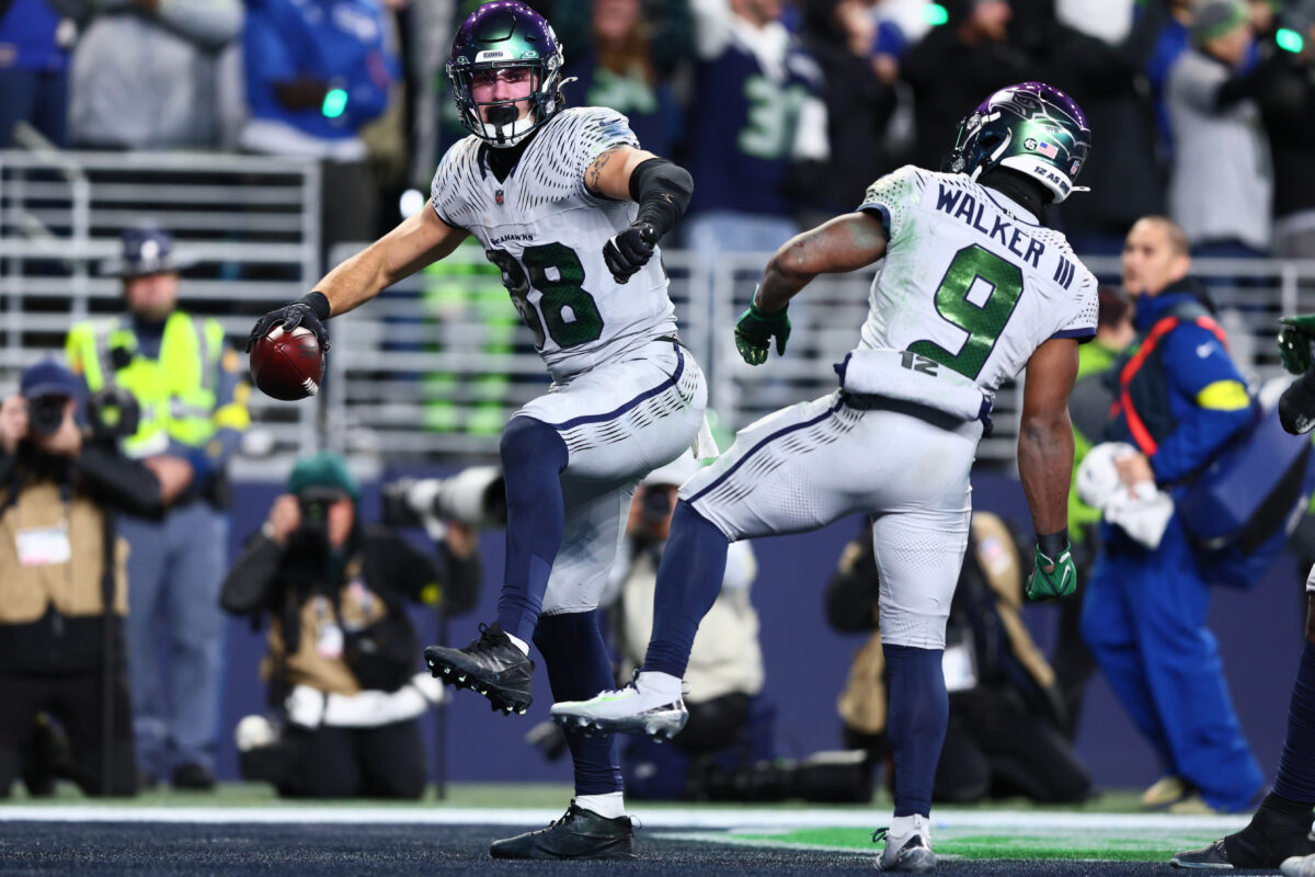 Playoffs da NFL Dec 18, 2025; Seattle, Washington, USA; Seattle Seahawks tight end AJ Barner (88) celebrates with running back Kenneth Walker III (9) after making a catch for a touchdown against the Los Angeles Rams in the second half at Lumen Field. Mandatory Credit: Kevin Ng-Imagn Images