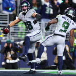 Playoffs da NFL Dec 18, 2025; Seattle, Washington, USA; Seattle Seahawks tight end AJ Barner (88) celebrates with running back Kenneth Walker III (9) after making a catch for a touchdown against the Los Angeles Rams in the second half at Lumen Field. Mandatory Credit: Kevin Ng-Imagn Images