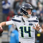 Playoffs da NFL Dec 28, 2025; Charlotte, North Carolina, USA; Seattle Seahawks quarterback Sam Darnold (14) throws a pass against the Carolina Panthers during the first quarter at Bank of America Stadium. Mandatory Credit: Bob Donnan-Imagn Images