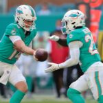Dec 28, 2025; Miami Gardens, Florida, USA; Miami Dolphins quarterback Quinn Ewers (14) hands the ball off to running back De'Von Achane (28) during the third quarter against the Tampa Bay Buccaneers at Hard Rock Stadium. Mandatory Credit: Sam Navarro-Imagn Images