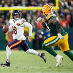 Dec 7, 2025; Green Bay, Wisconsin, USA; Chicago Bears quarterback Caleb Williams (18) scrambles out of the pocket in the third quarter against the Green Bay Packers at Lambeau Field. Mandatory Credit: Jeff Hanisch-Imagn Images