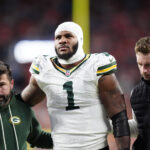 Dec 14, 2025; Denver, Colorado, USA; Green Bay Packers defensive end Micah Parsons (1) walks off the field with help from medical personnel following an injury during the third quarter against the Denver Broncos at Empower Field at Mile High. Mandatory Credit: Ron Chenoy-Imagn Images