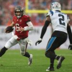 Jan 3, 2026; Tampa, Florida, USA; Tampa Bay Buccaneers quarterback Baker Mayfield (6) runs against Carolina Panthers cornerback Mike Jackson (2) in the first half at Raymond James Stadium.