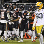 Jan 10, 2026; Chicago, IL, USA; Chicago Bears quarterback Caleb Williams (18) and wide receiver DJ Moore (2) react after hooking up on the eventually game winning touchdown against the Green Bay Packers during the second half of an NFC Wild Card Round game at Soldier Field. Mandatory Credit: Matt Marton-Imagn Images