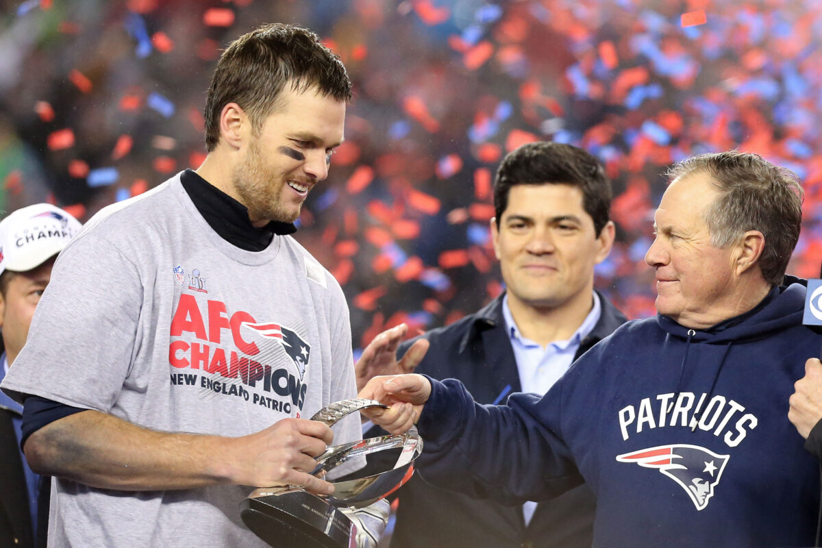 Jan 22, 2017; Foxborough, MA, USA; New England Patriots head coach Bill Belichick (R) hands the Lamar Hunt AFC championship trophy to Patriots quarterback Tom Brady (L) on the victory podium after the Patriots defeated the Pittsburgh Steelers in the 2017 AFC Championship Game at Gillette Stadium. Mandatory Credit: Geoff Burke-USA TODAY Sports