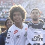 Kauan Basile, atacante de 13 anos de idade do Santos, segurando camisa do clube paulista em estádio